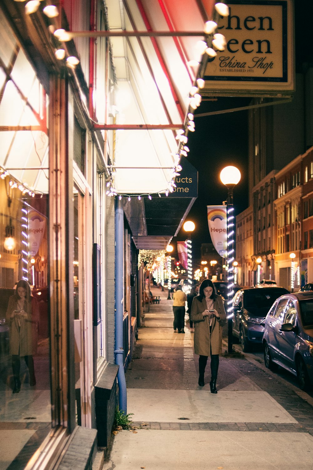 people walking on sidewalk during night time