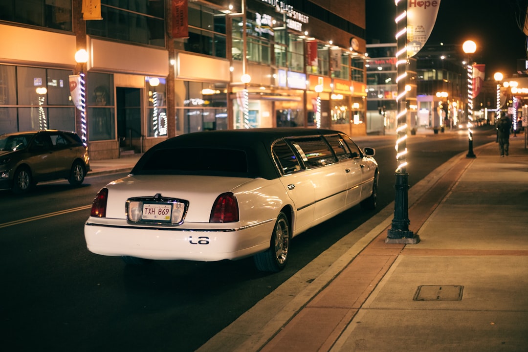 white sedan parked on sidewalk during night time