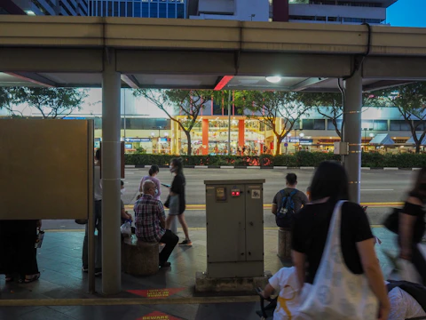 A vibrant smart city street with connected sensors, electric buses, and people using mobile devices.