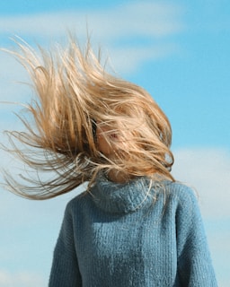 woman in gray sweater under blue sky during daytime