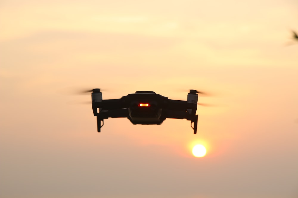 Schwarze Drohne, die bei Sonnenuntergang fliegt