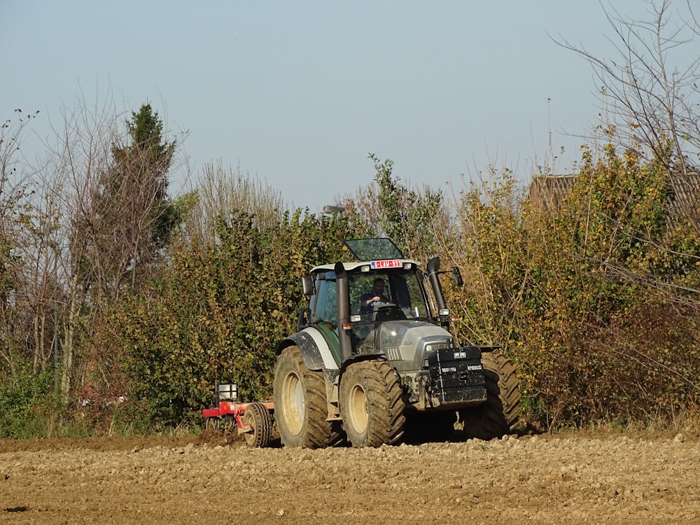 blue tractor on brown grass field during daytime