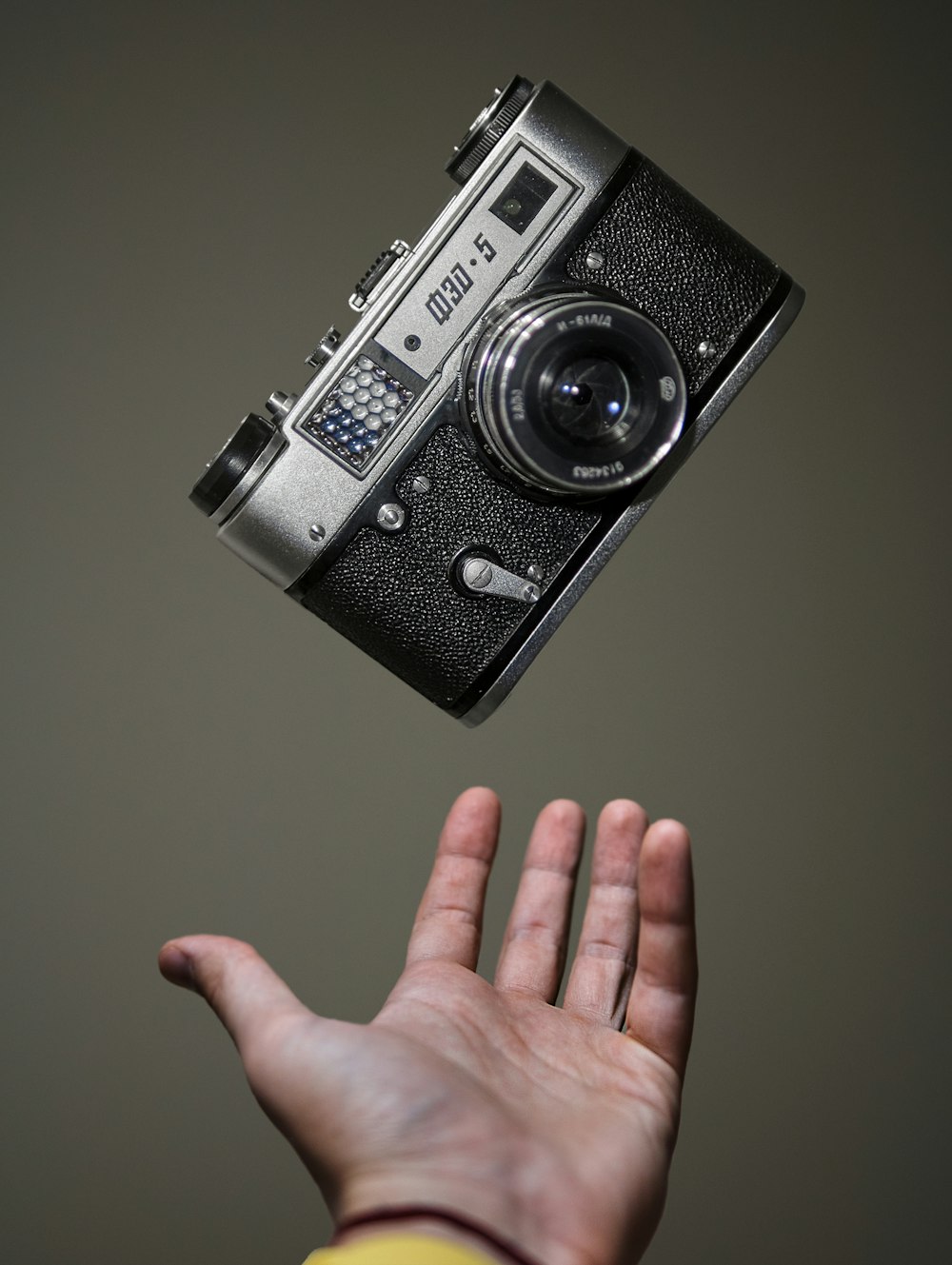 person holding black and silver camera