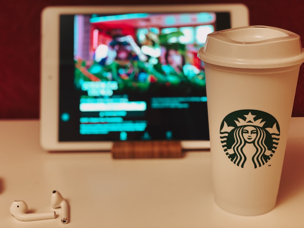 Taza blanca de Starbucks sobre mesa blanca