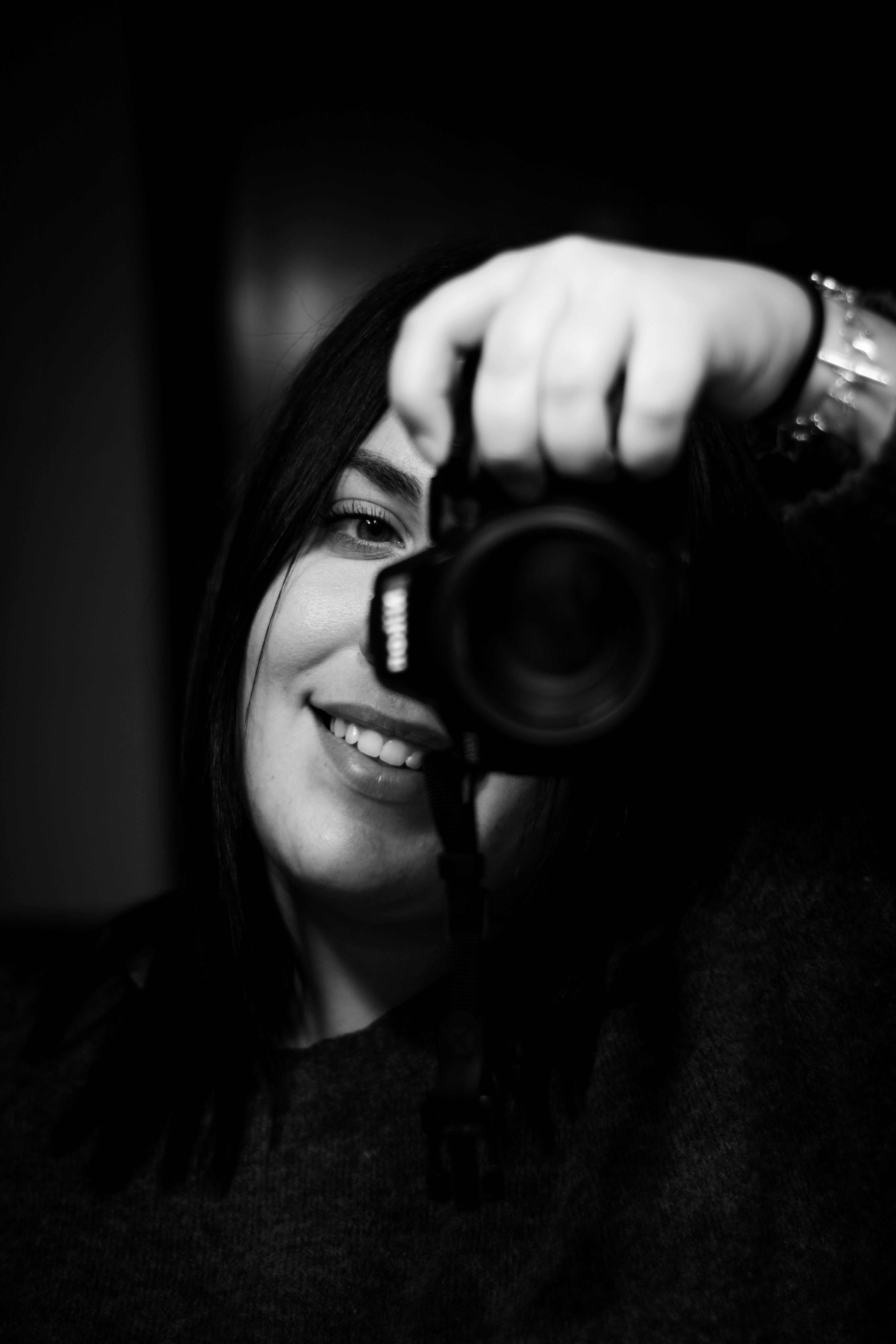 grayscale photo of woman holding camera