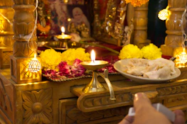 A peaceful altar with a glowing diya lamp and sacred texts arranged neatly.