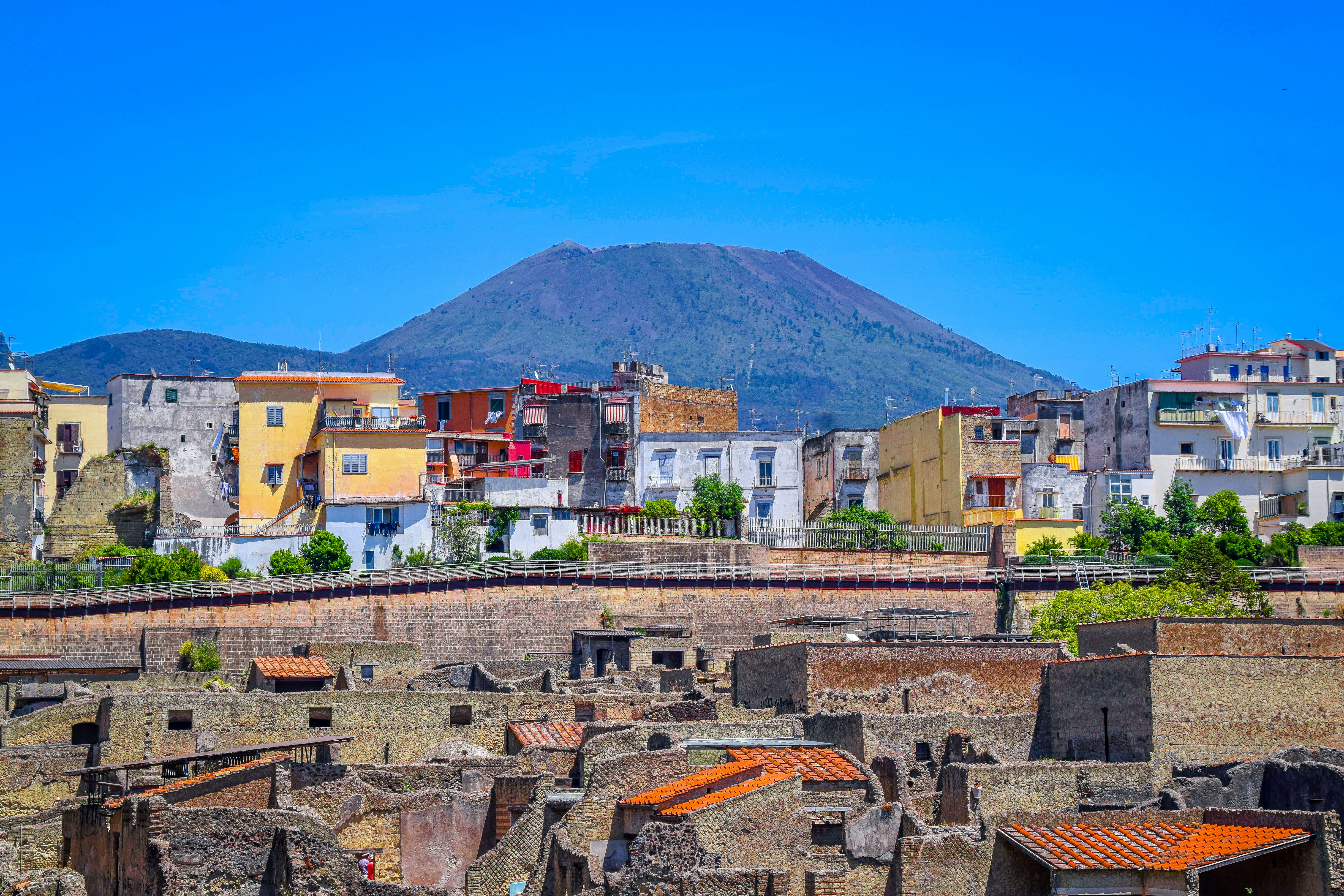 brown and white concrete buildings near mountain under blue sky during daytime