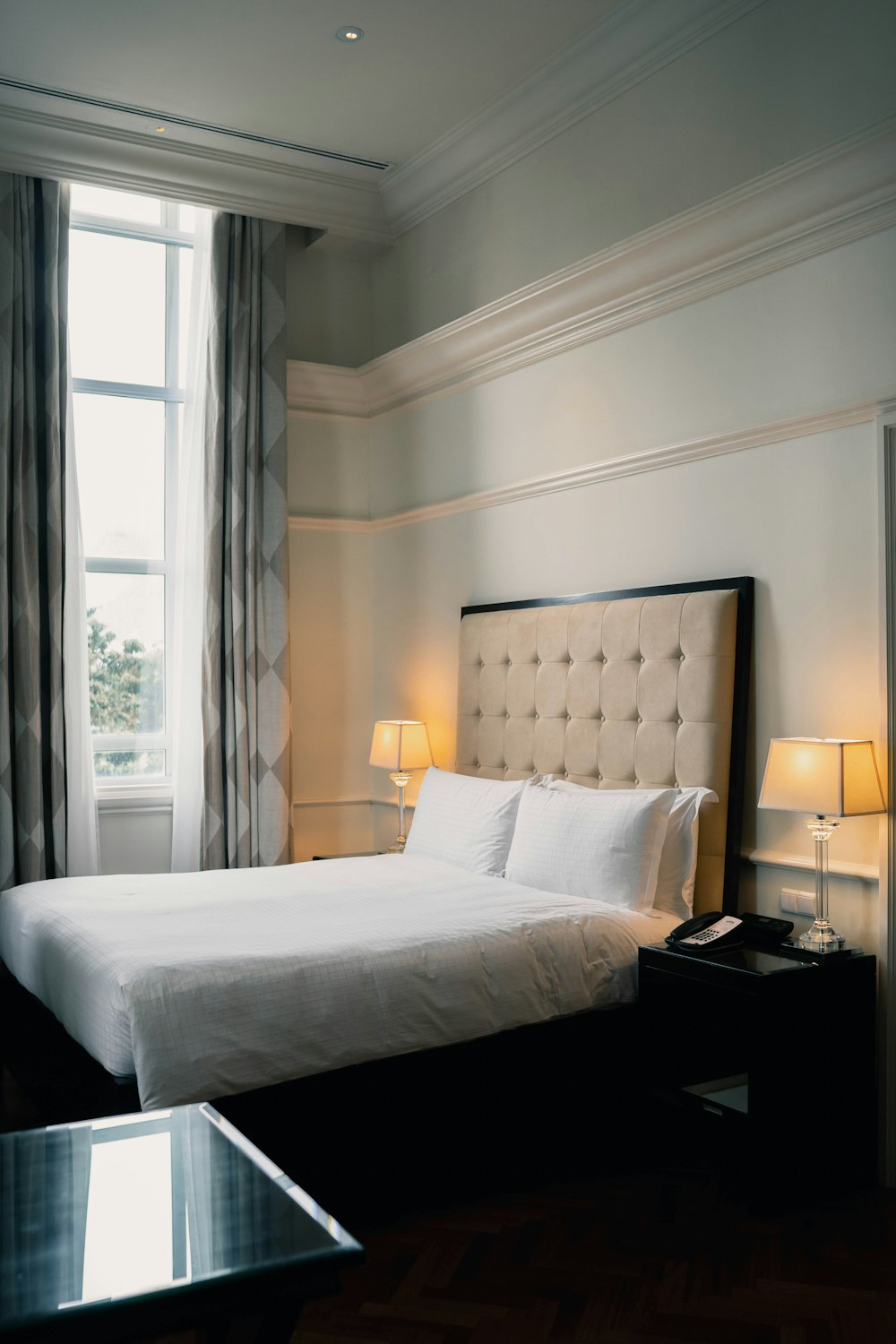 white bed linen near black wooden nightstand