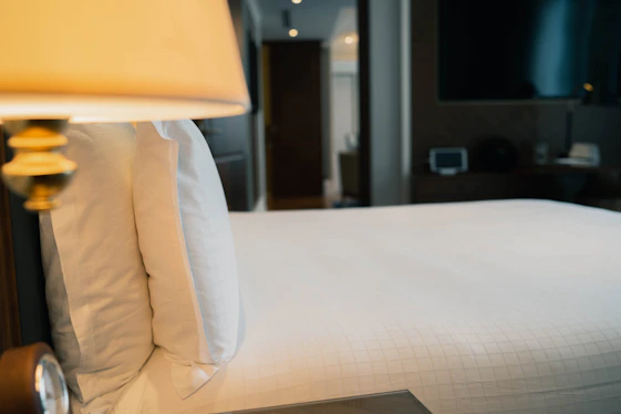 white bed linen near white wall