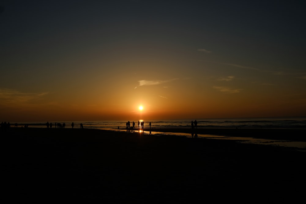 silhouette of people on beach during sunset