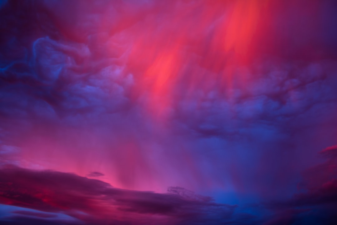 a red and blue sky filled with lots of clouds,