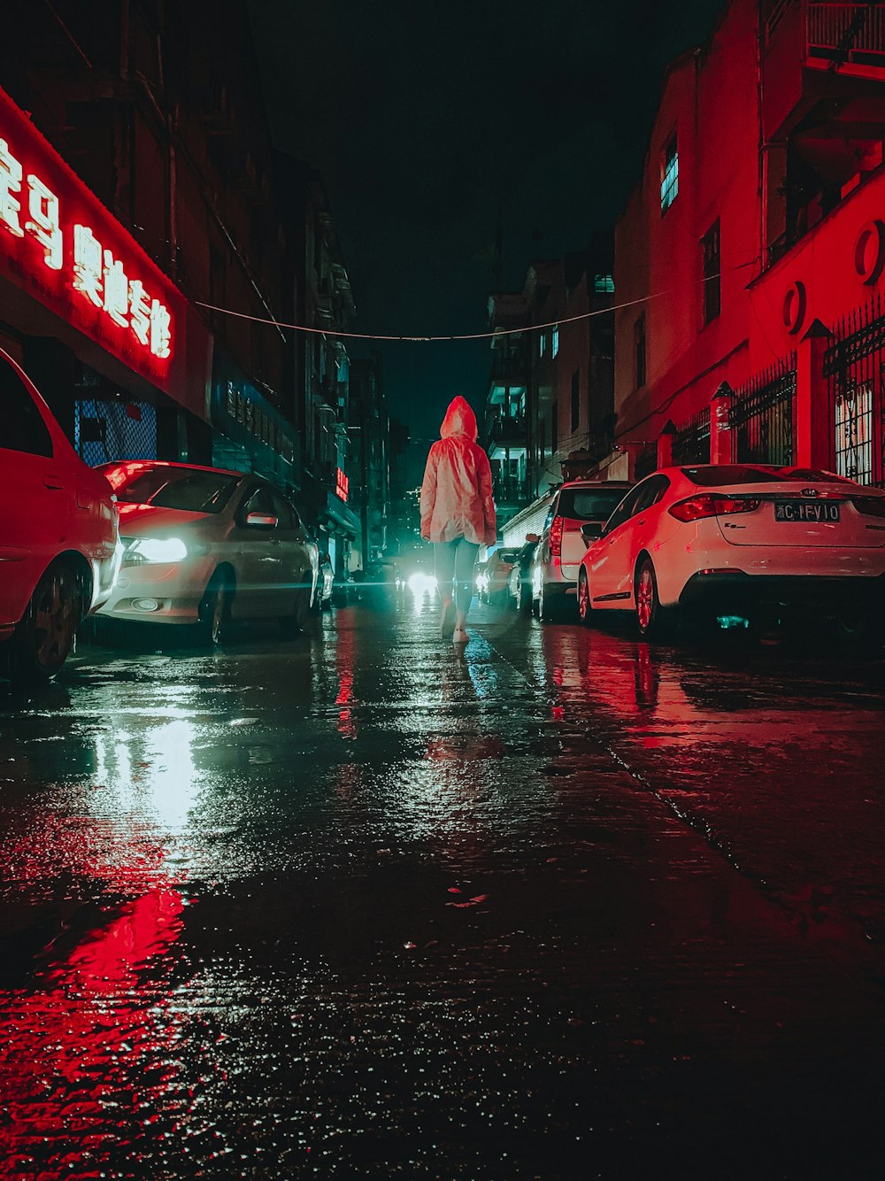person in white robe walking on street during night time
