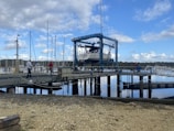 Boat lift mechanism in action, gently raising a boat from the water beside a dock.