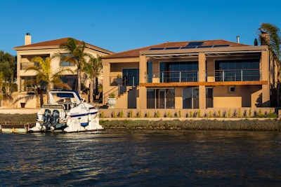 Modern coastal villa featuring a boat lift and palm trees swaying in the breeze.