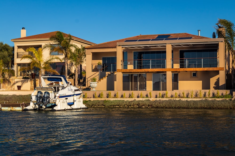 white and black motor boat on water near brown concrete building during daytime