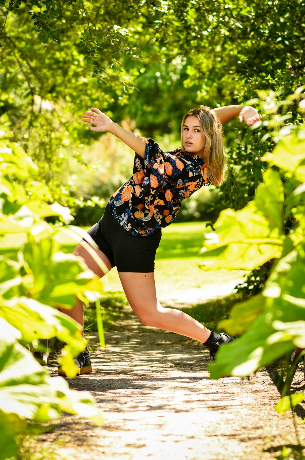 woman in black and white floral shirt and black shorts standing on water during daytime