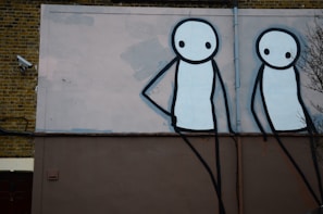 Night vision security camera still showing two figures loitering suspiciously near a residential door