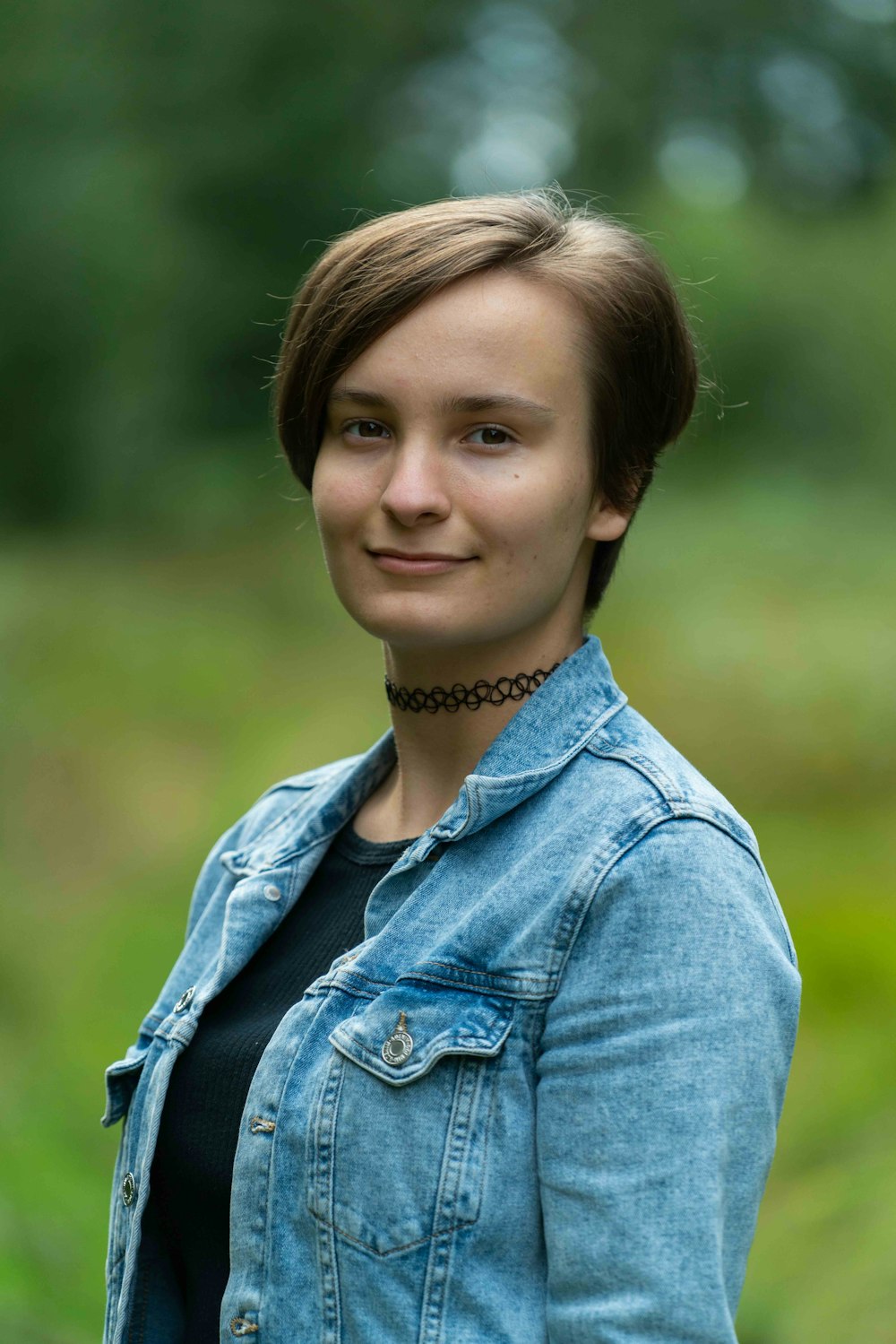 femme en veste en jean bleu souriante