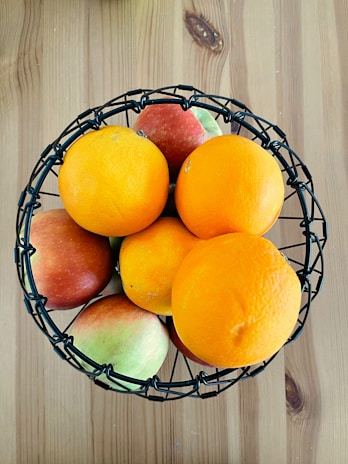 Baskets filled with colorful organic fruits arranged on a wooden table.