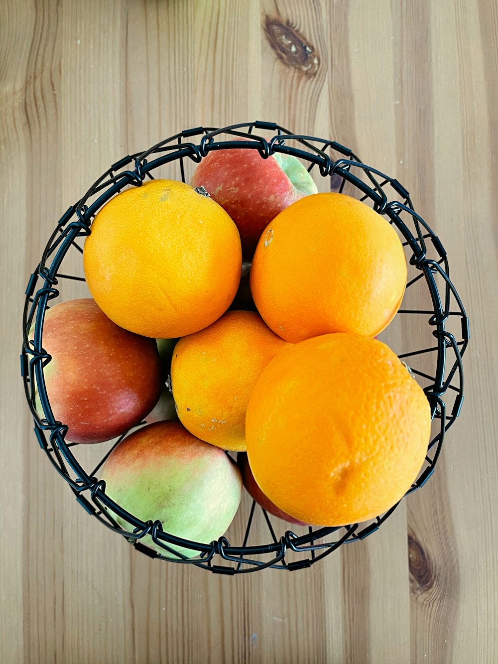 Frutas naranjas en cesta de frutas de metal negro
