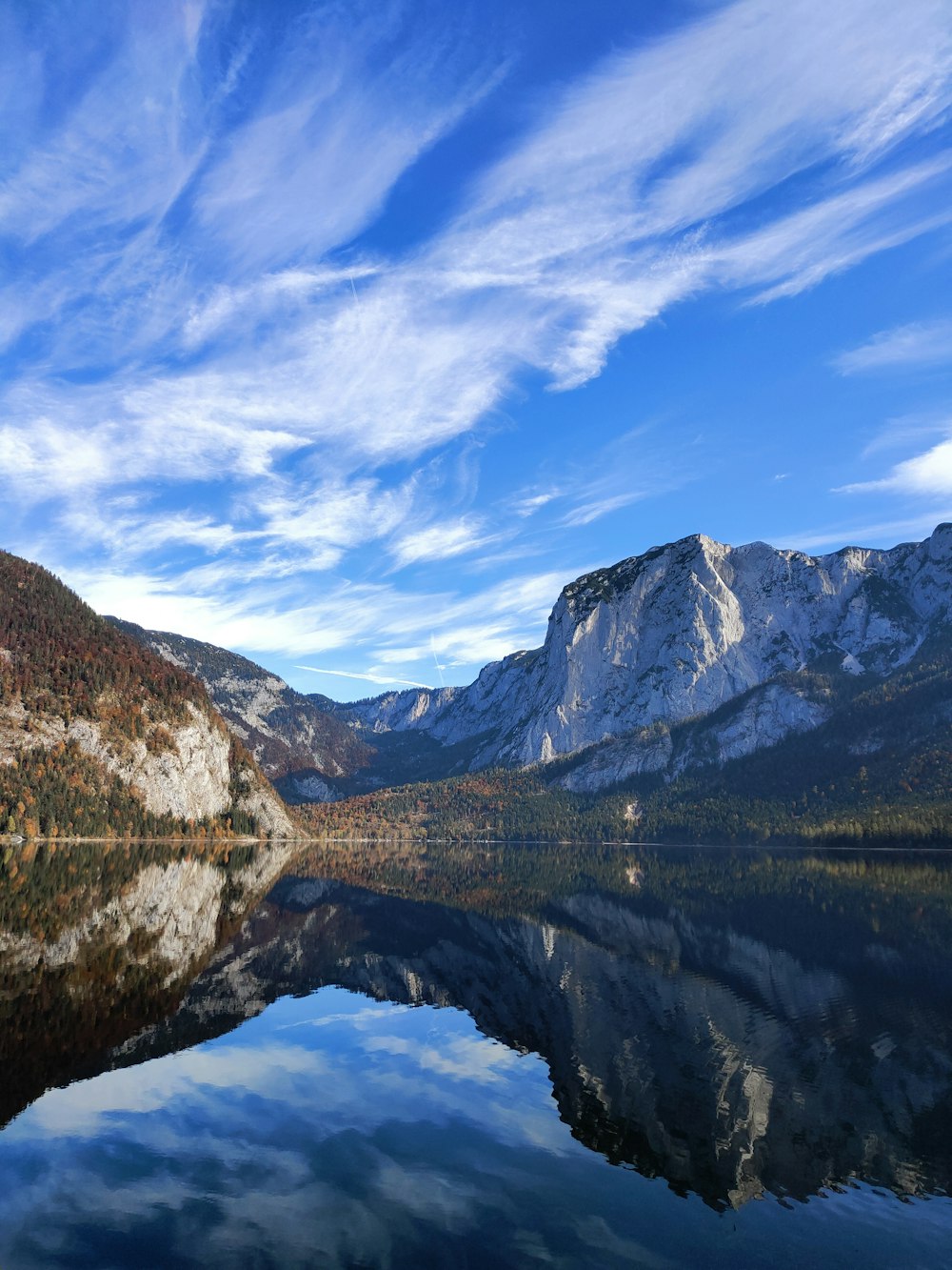 body of water near mountain under blue sky during daytime