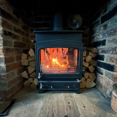 black wood burner near brown brick wall