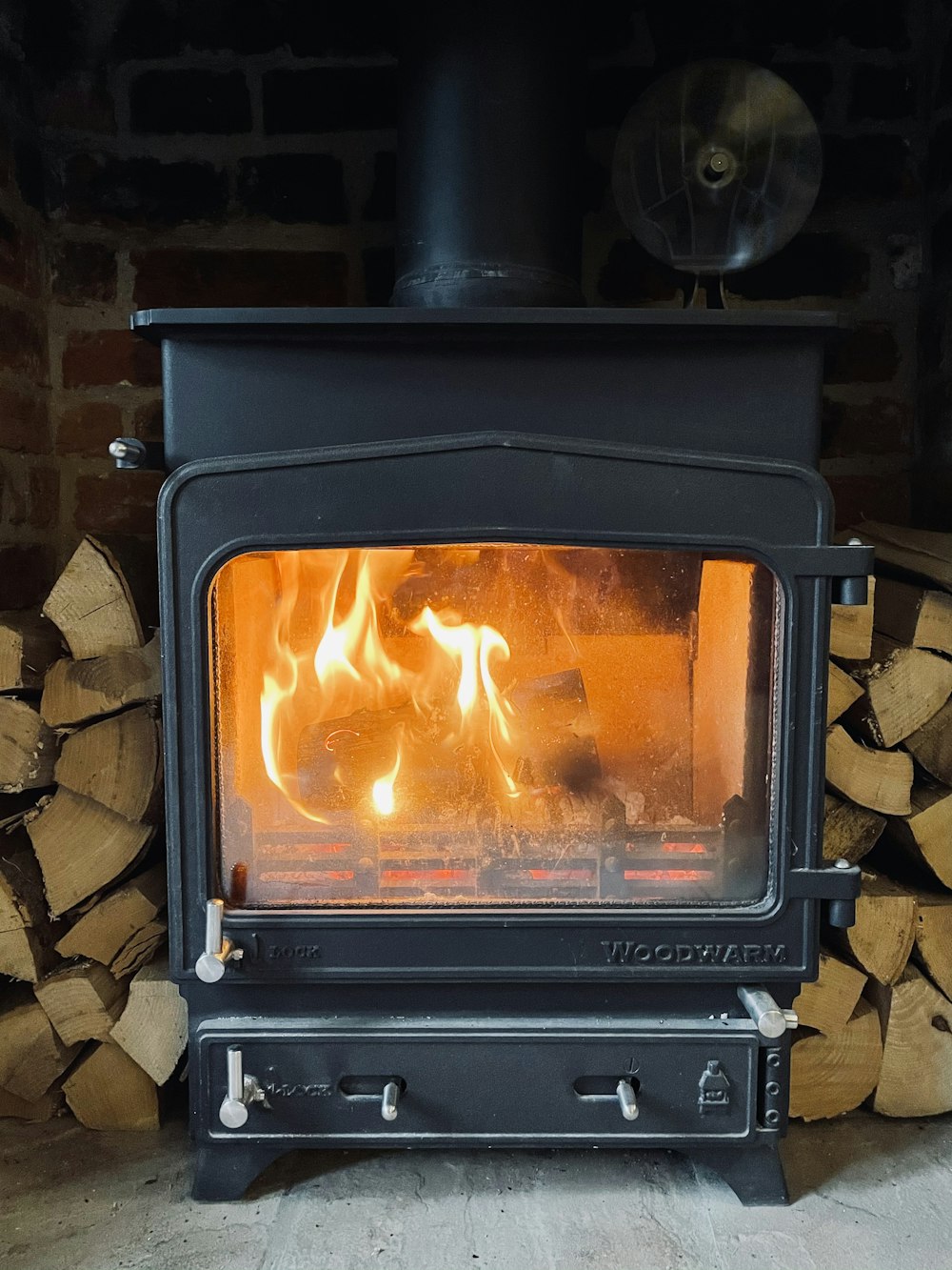 black wood burner near brown brick wall