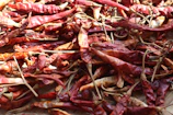 Close-up of vibrant Kashmiri dry red chillies drying under the sun.