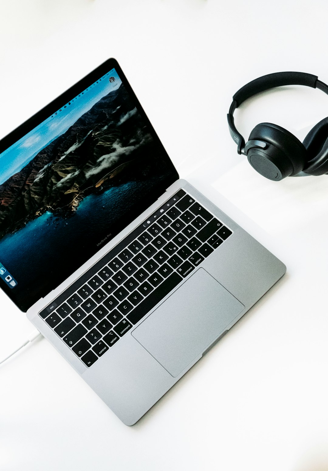 macbook pro beside black headphones