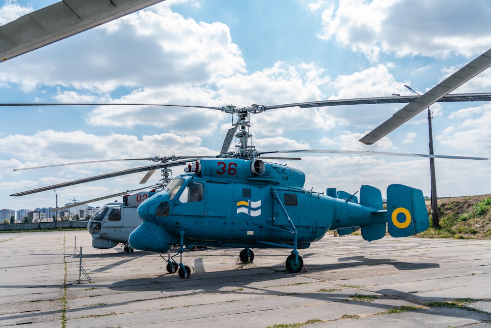 blue and white helicopter on gray concrete floor during daytime