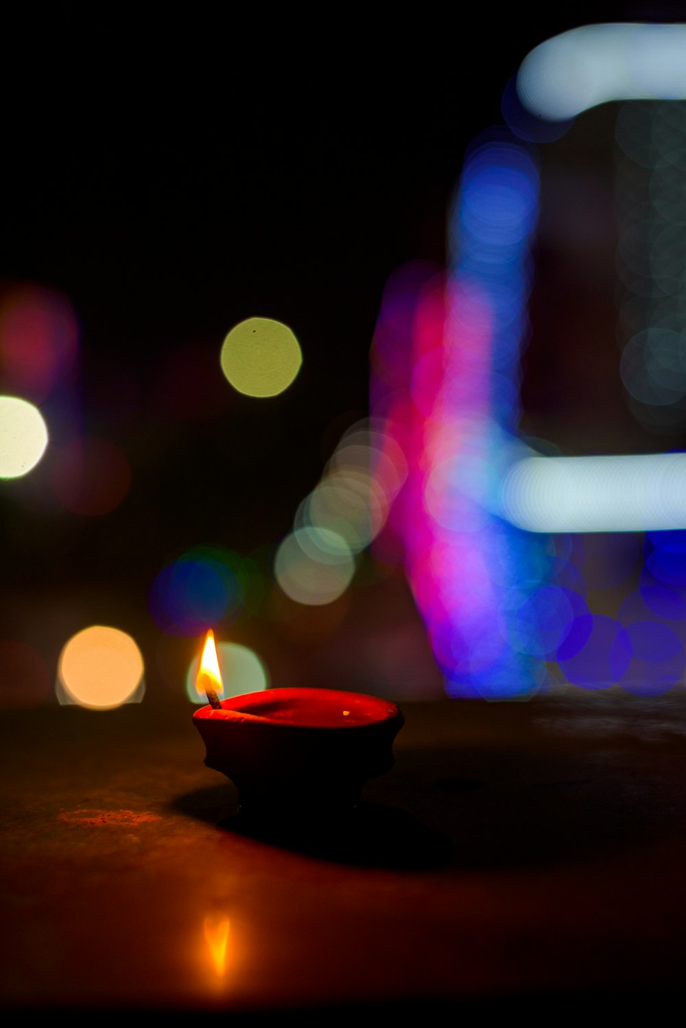 red candle holder with yellow and red bokeh lights
