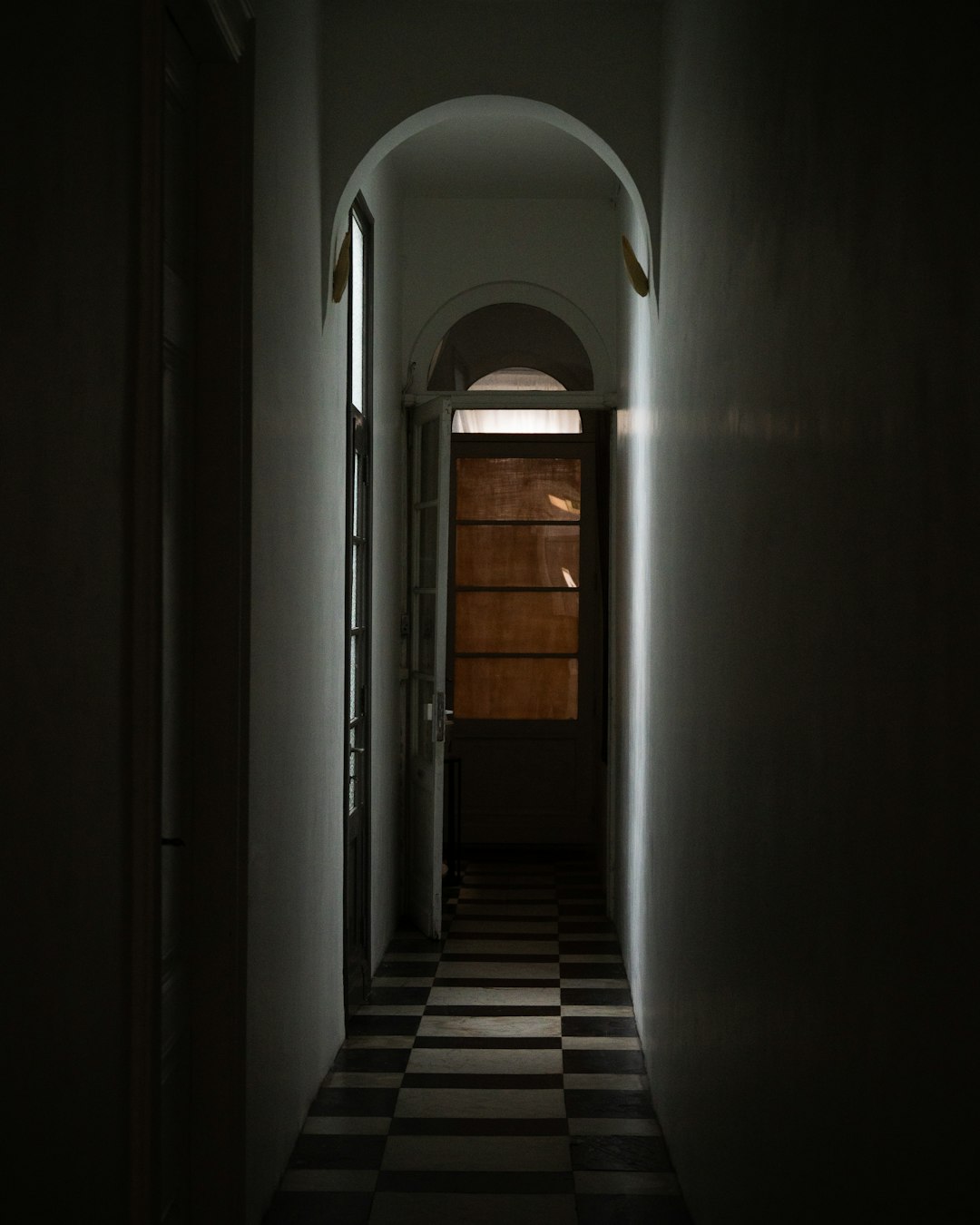 white concrete hallway with brown wooden doors