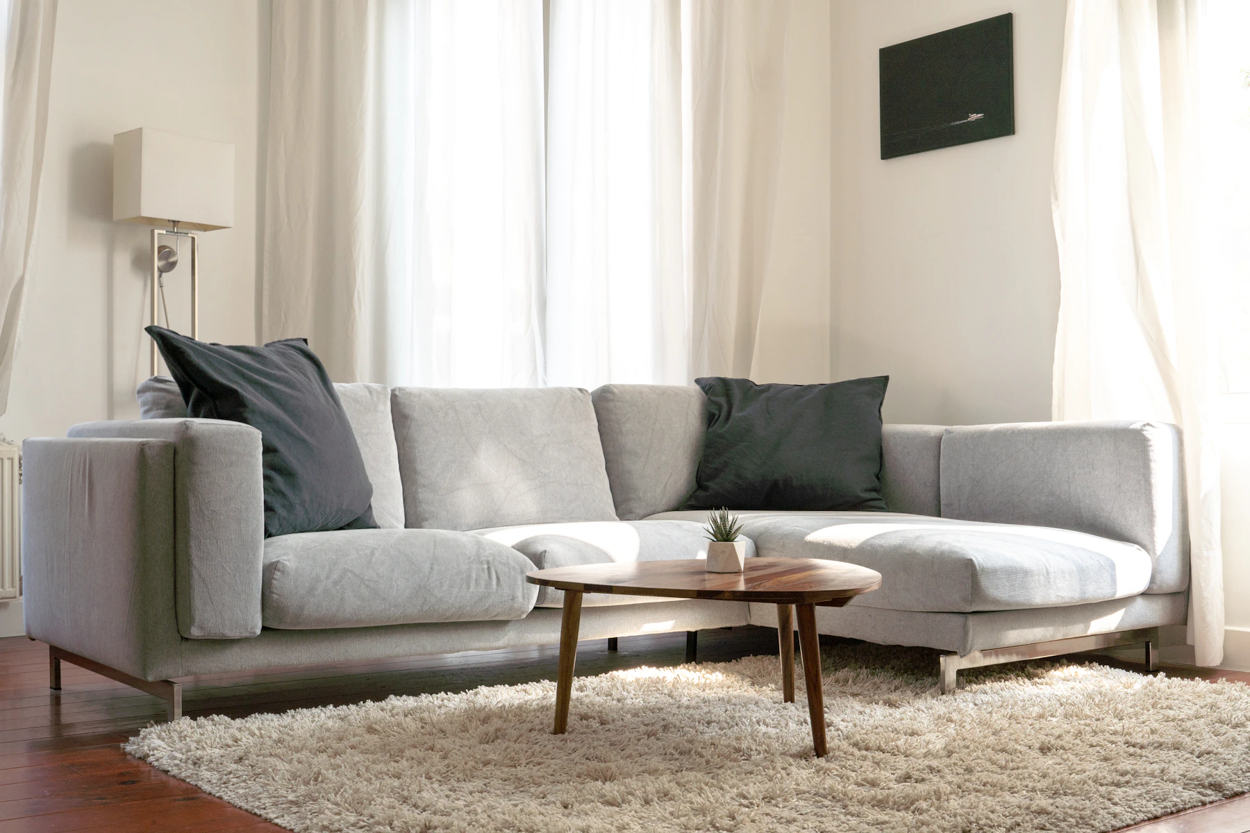 A gray sofa styled with neutral handwoven throw pillows