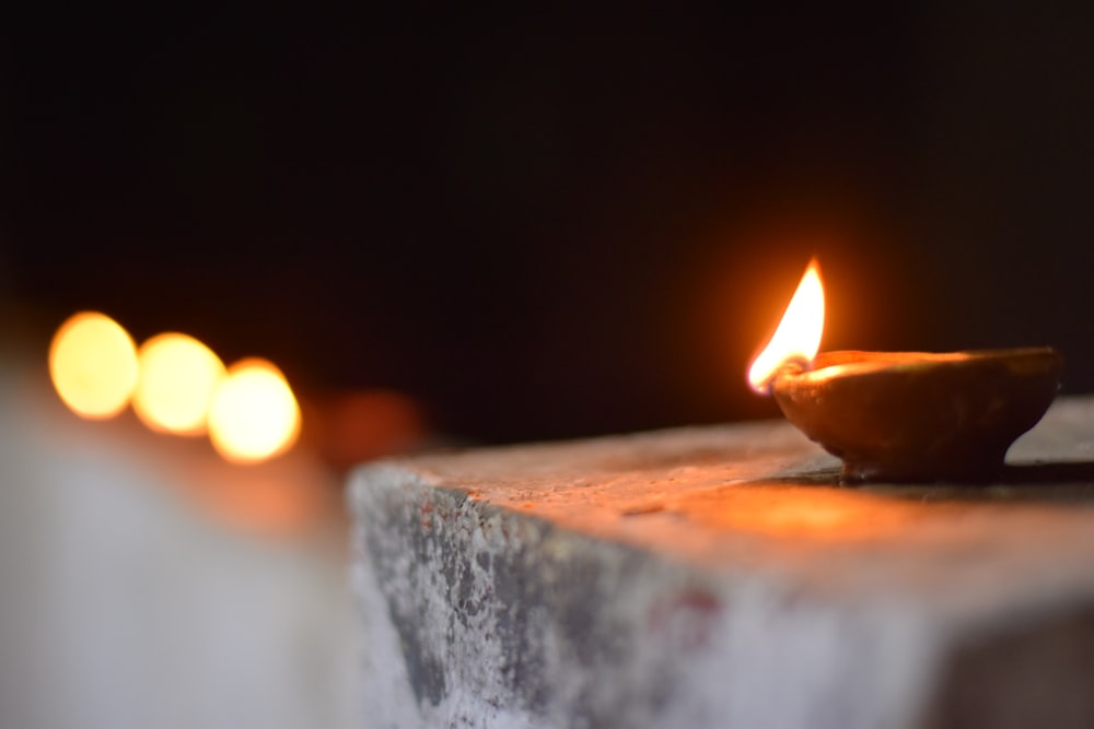 lighted candle on brown wooden table