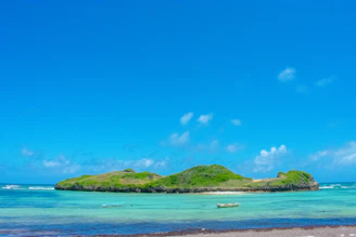 A small boat approaching a lush island with clear blue waters.