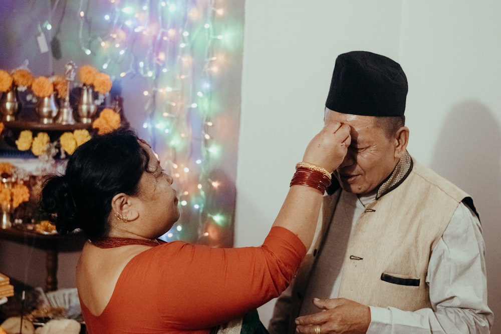 man in black hat kissing woman in orange tank top