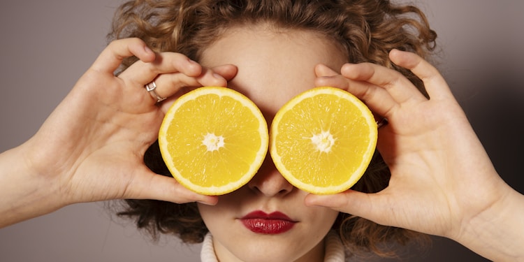 woman holding sliced orange fruit