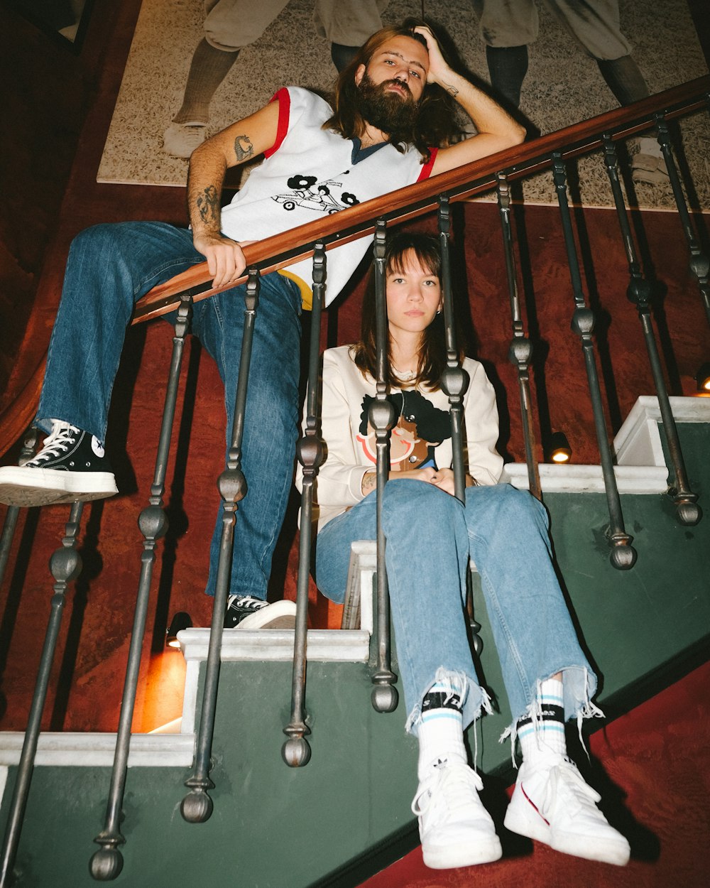 woman in blue denim jeans sitting on brown wooden staircase