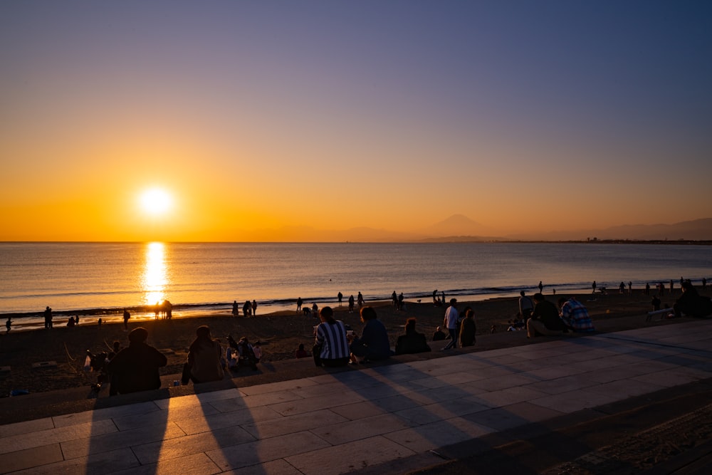 Gente en la playa durante la puesta de sol