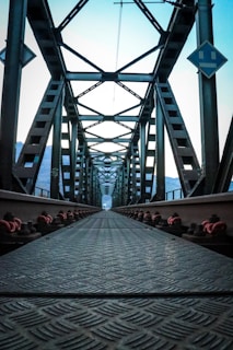 Symmetrical thumbnail of steel beams forming geometric patterns on a bridge