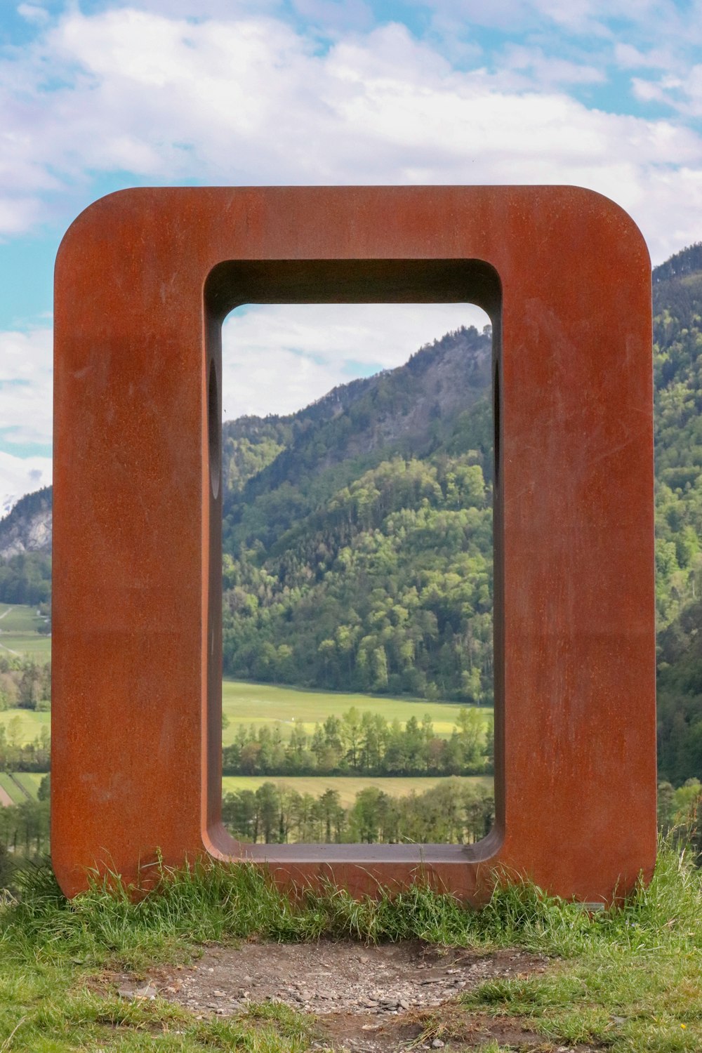 brown wooden frame with green trees in the distance