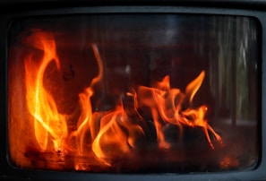 Soft orange fire tones flickering inside a pellet stove, symbolizing the efficient heat from dafa biomass pellets