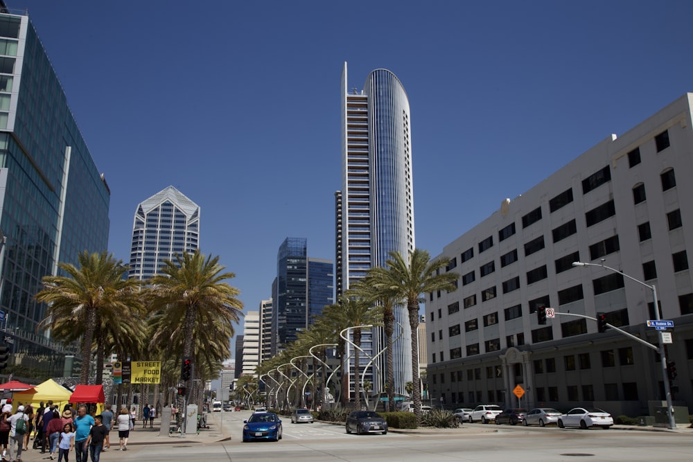 cars parked on parking lot near high rise buildings during daytime