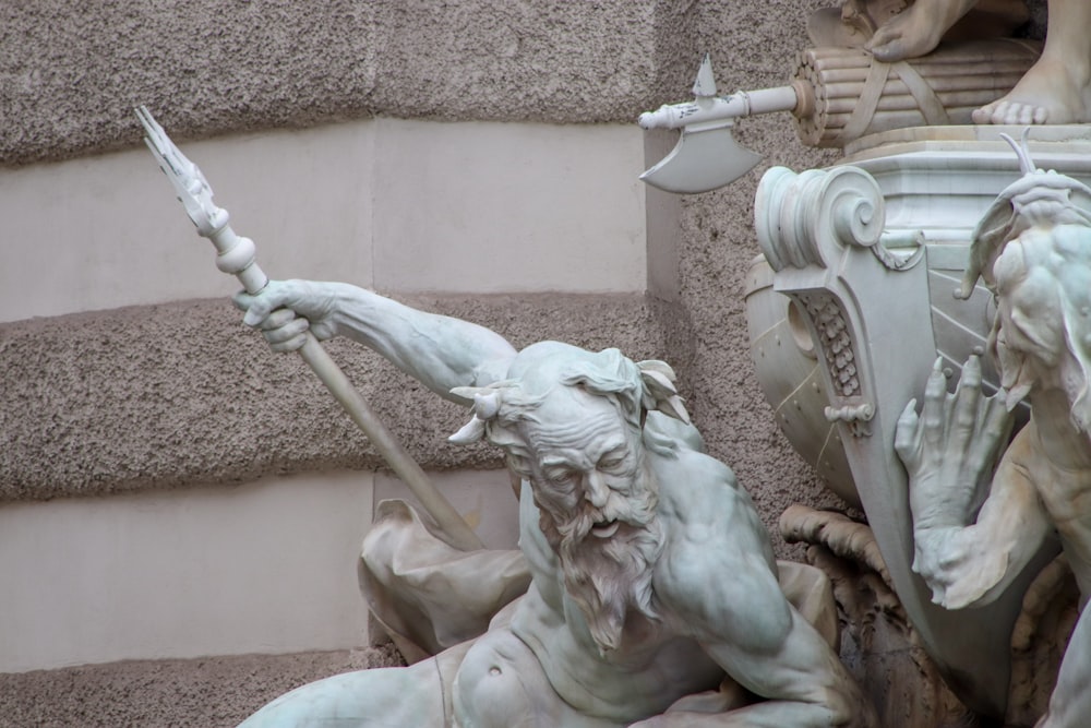 man holding a stick statue