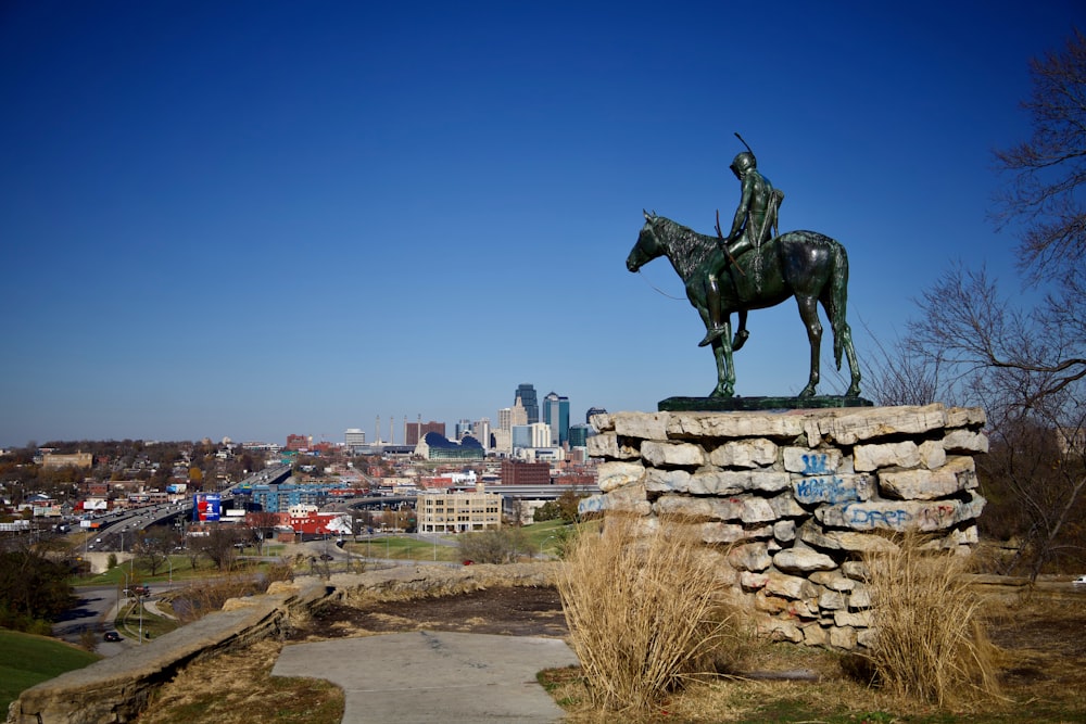 Estatua de caballo negro cerca de la pared de ladrillo marrón durante el día