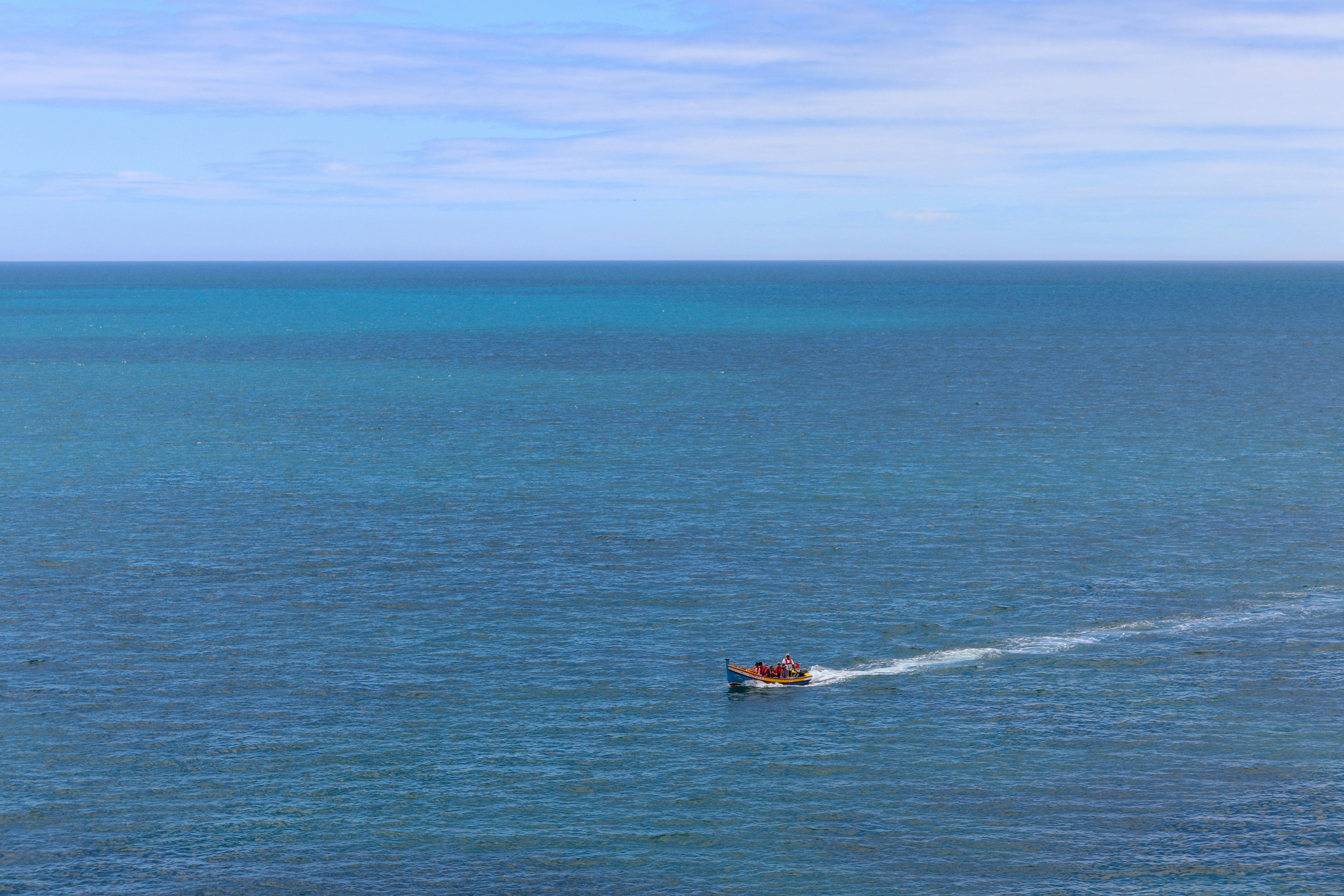 red and black boat on blue sea during daytime