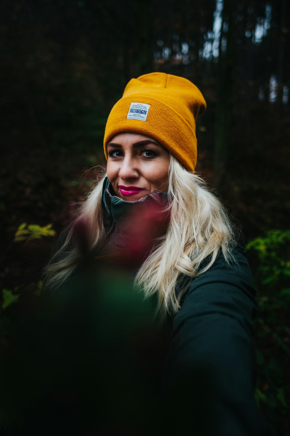 woman in black jacket wearing yellow knit cap