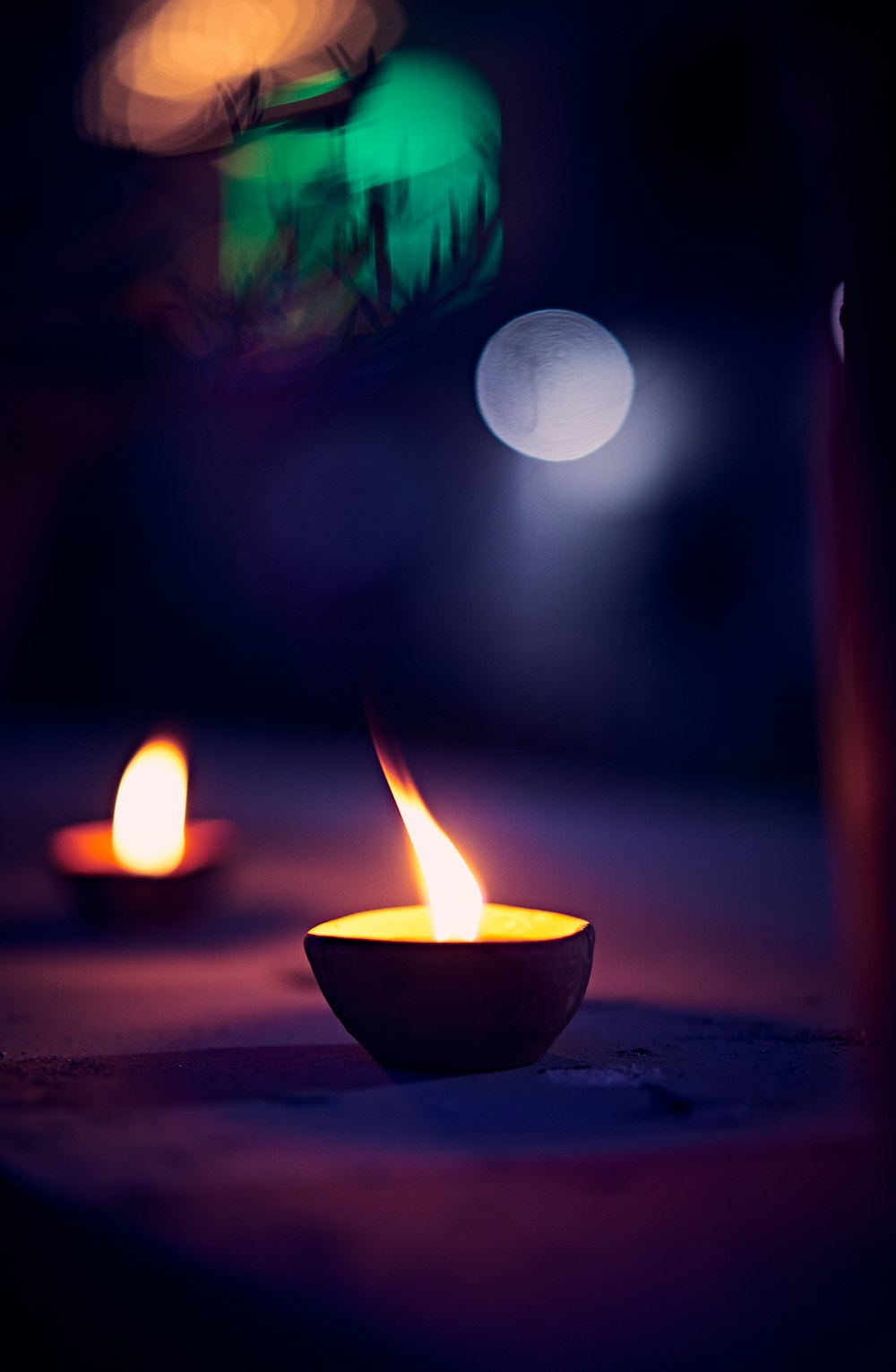 lighted candle in black round bowl