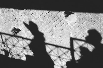 Shadowed figure observing a couple from a distance.