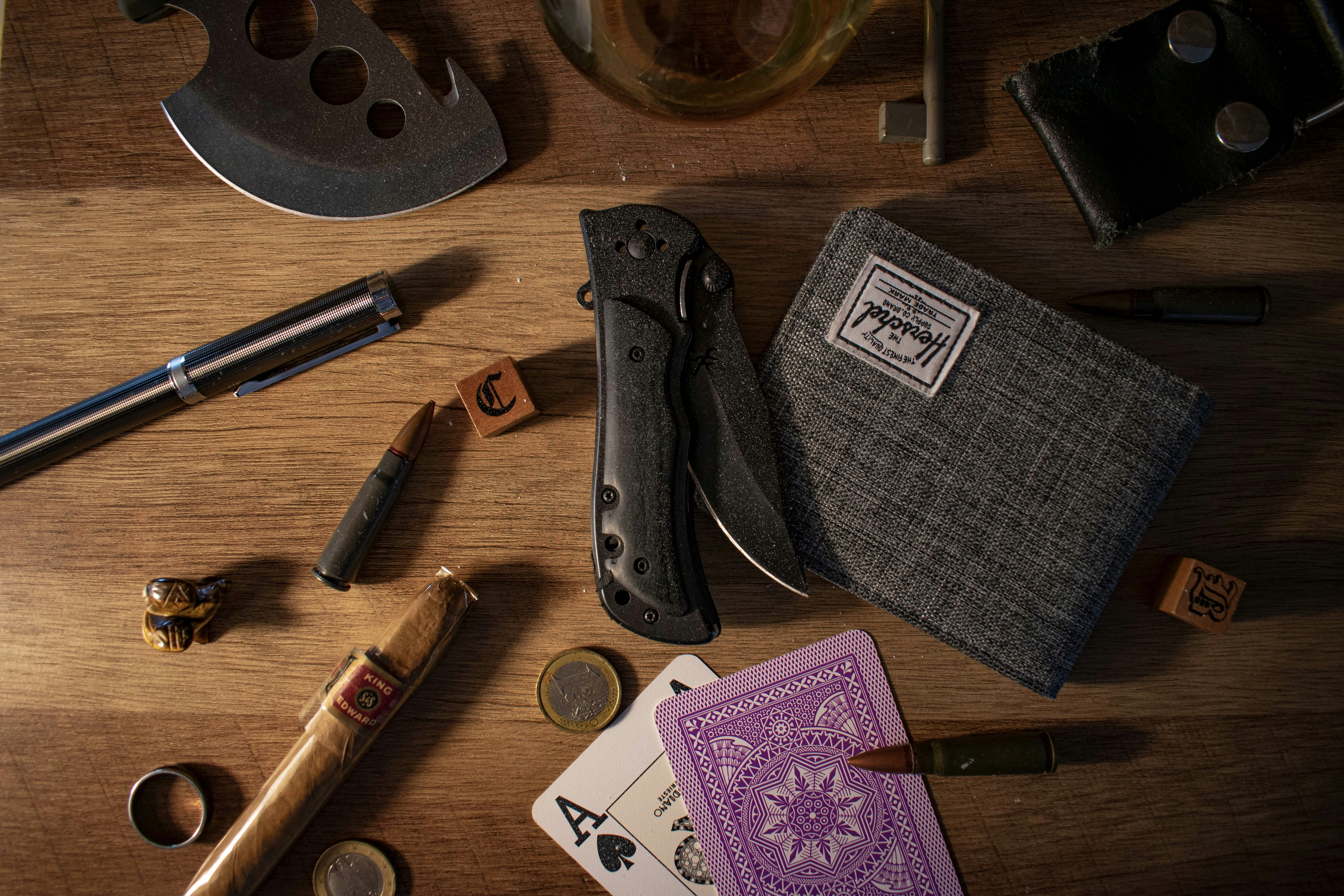 Tactical tools and personal accessories arranged on a wooden surface.